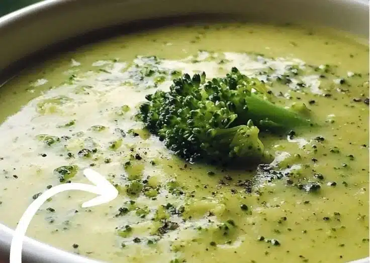 Delicious bowl of easy creamy broccoli soup topped with fresh herbs.
