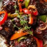 Plate of authentic Jamaican Brown Stew Chicken with vibrant vegetables