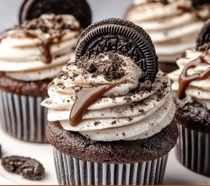 Delicious Oreo Cupcakes topped with cream and Oreo cookie crumbles