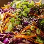 Vibrant Asian cabbage salad topped with sesame ginger dressing in a bowl